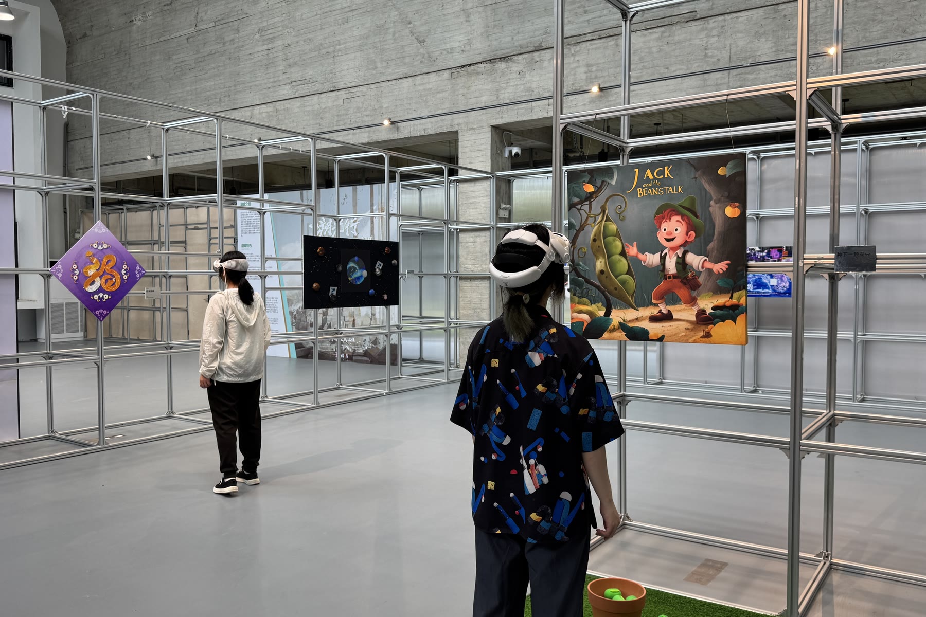一位参观者戴着头显，站在展览的印刷作品前