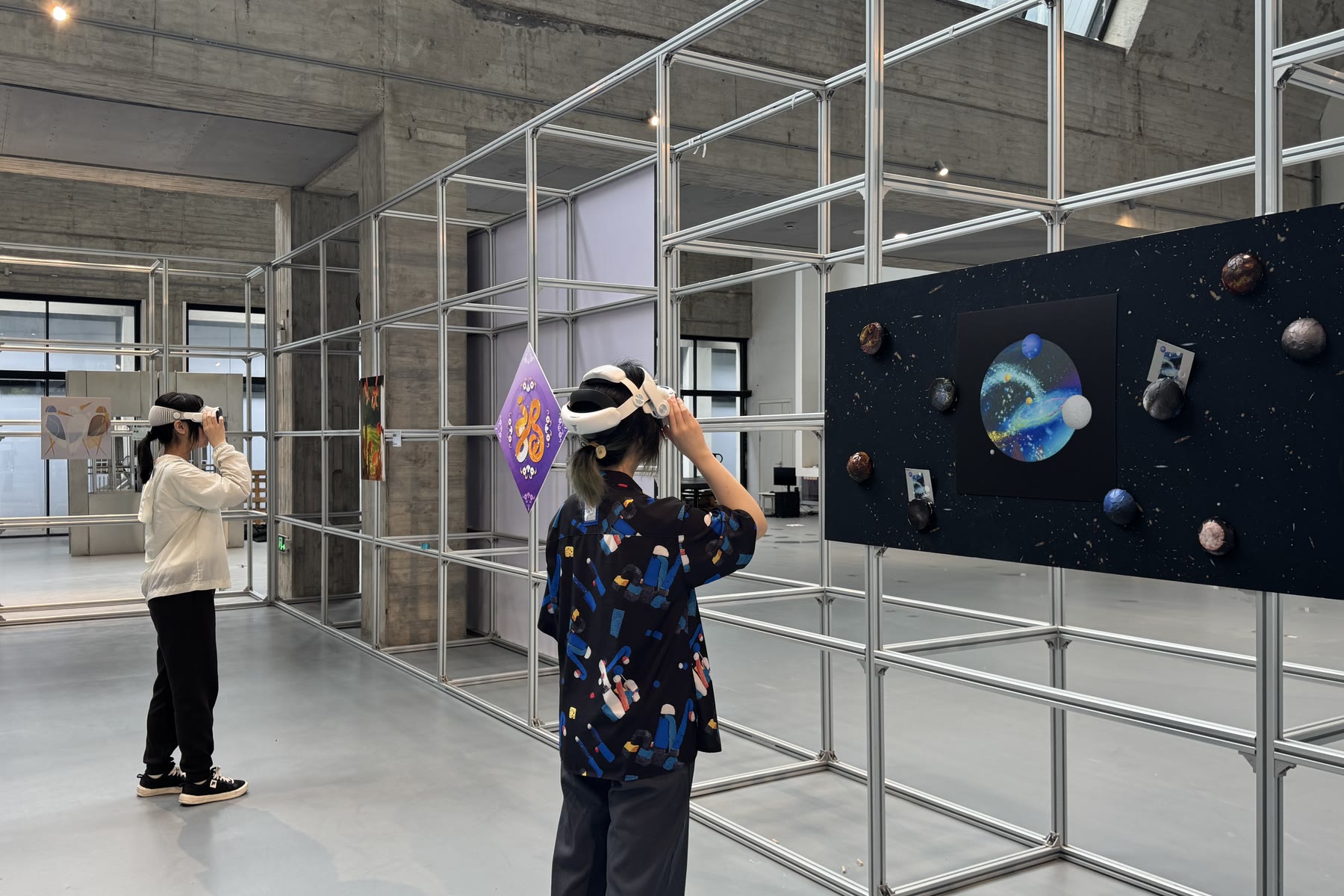 中国美术学院展览现场，一名学生戴着头显站在空间作品旁
